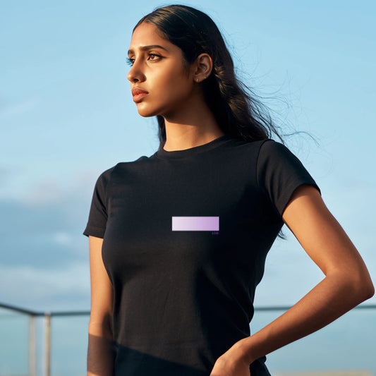 Woman wearing a premium supima cotton black t-shirt with a stylish gradient against a blue sky.