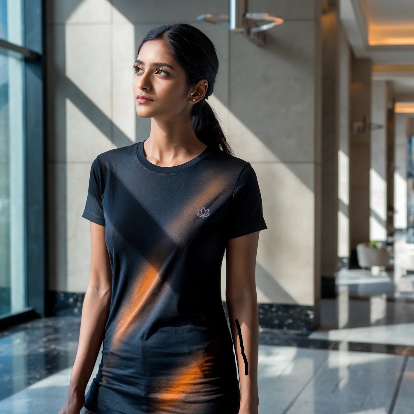 Black women’s luxury Supima cotton t-shirt featuring subtle lotus logo, modern minimalist streetwear fashion