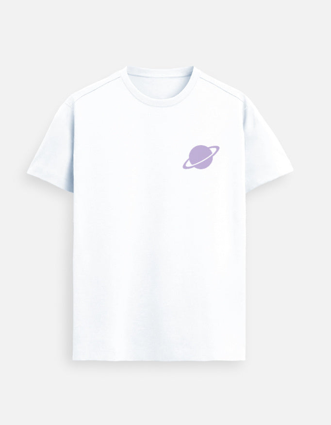 Male model walking confidently down an urban city street wearing a White Supima cotton T-shirt by Lilak, featuring a small lavender planet graphic on the left chest