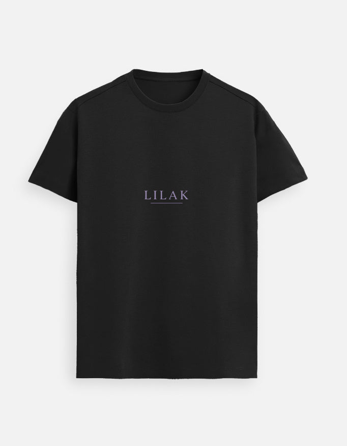 Black minimalist women’s t-shirt with lilac “LILAK” logo, worn by a confident woman on a European city street, premium casual streetwear style