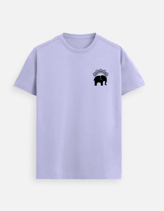 Man wearing a Lavender Lilak Supima cotton T-shirt with a small black elephant emblem on the left chest, standing against a soft neutral studio background