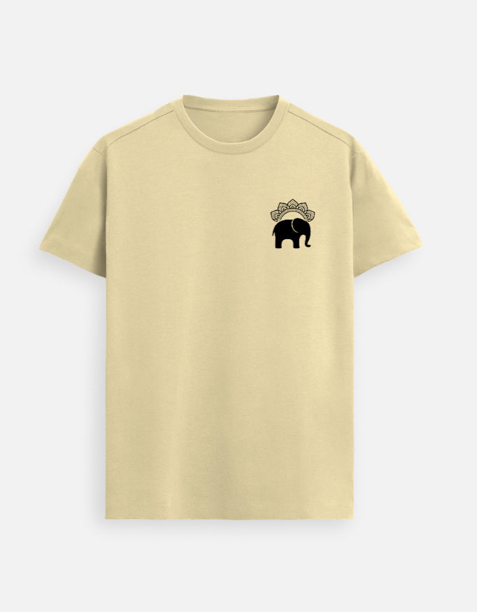 Man wearing a Beige Lilak Supima cotton T-shirt with a small black elephant emblem on the left chest, standing against a soft neutral studio background